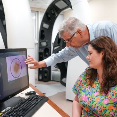 Researchers studying skin lesions on computer image. Credit, UQ 